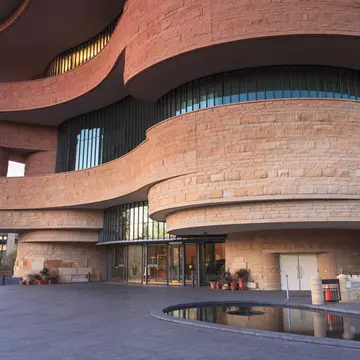 WASHINGTON, DC - NOVEMBER 30:  The entrance to the National Museum of the American Indian, as seen November 30, 2013, showcases the unusual curved architecture of the stone building.; Shutterstock ID 166031348; Your name (First / Last): Josh Vogel...