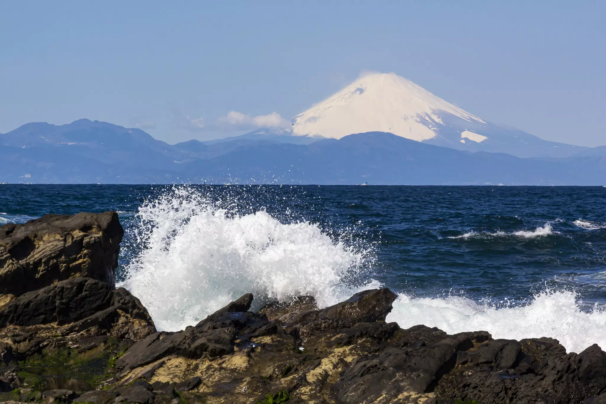 Waves hit Shonan Beach with a view of snow-capped Mt Fuji in the distance.