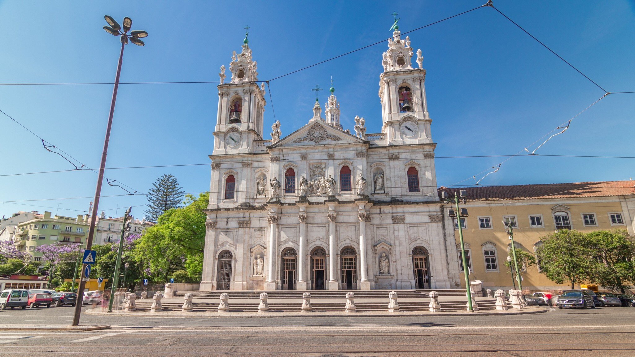 Front view on the Basilica da Estrela from the streets of Lisbon timelapse hyperlapse, Portugal. Traffic on the street and blue sky