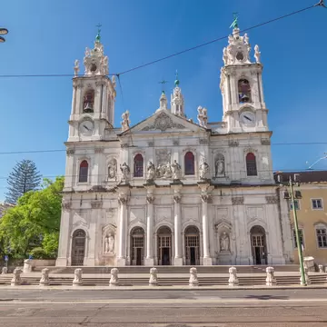 Front view on the Basilica da Estrela from the streets of Lisbon timelapse hyperlapse, Portugal. Traffic on the street and blue sky