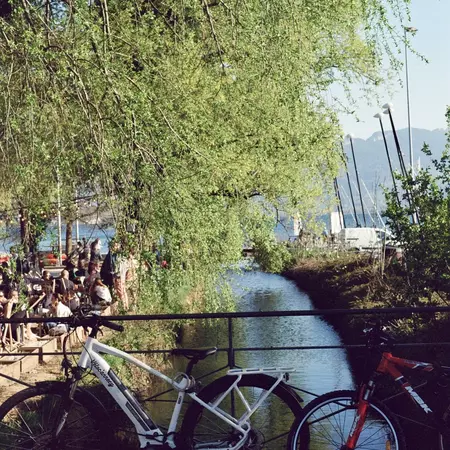 A canal through a small town with two bikes parked on the bridge
