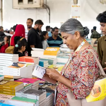 People browse at tables of books.