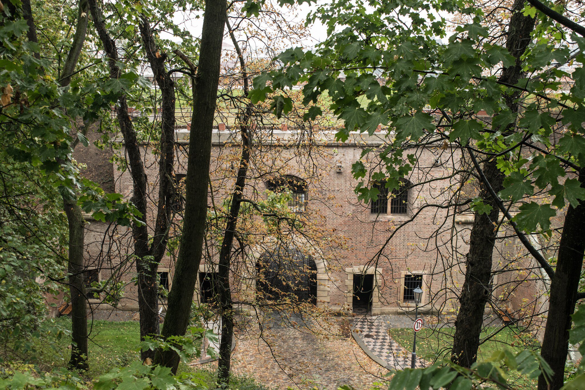Prague, Czech Republic. Overhead view of the brick gate to the fortress Vysehrad with trees in the foreground.