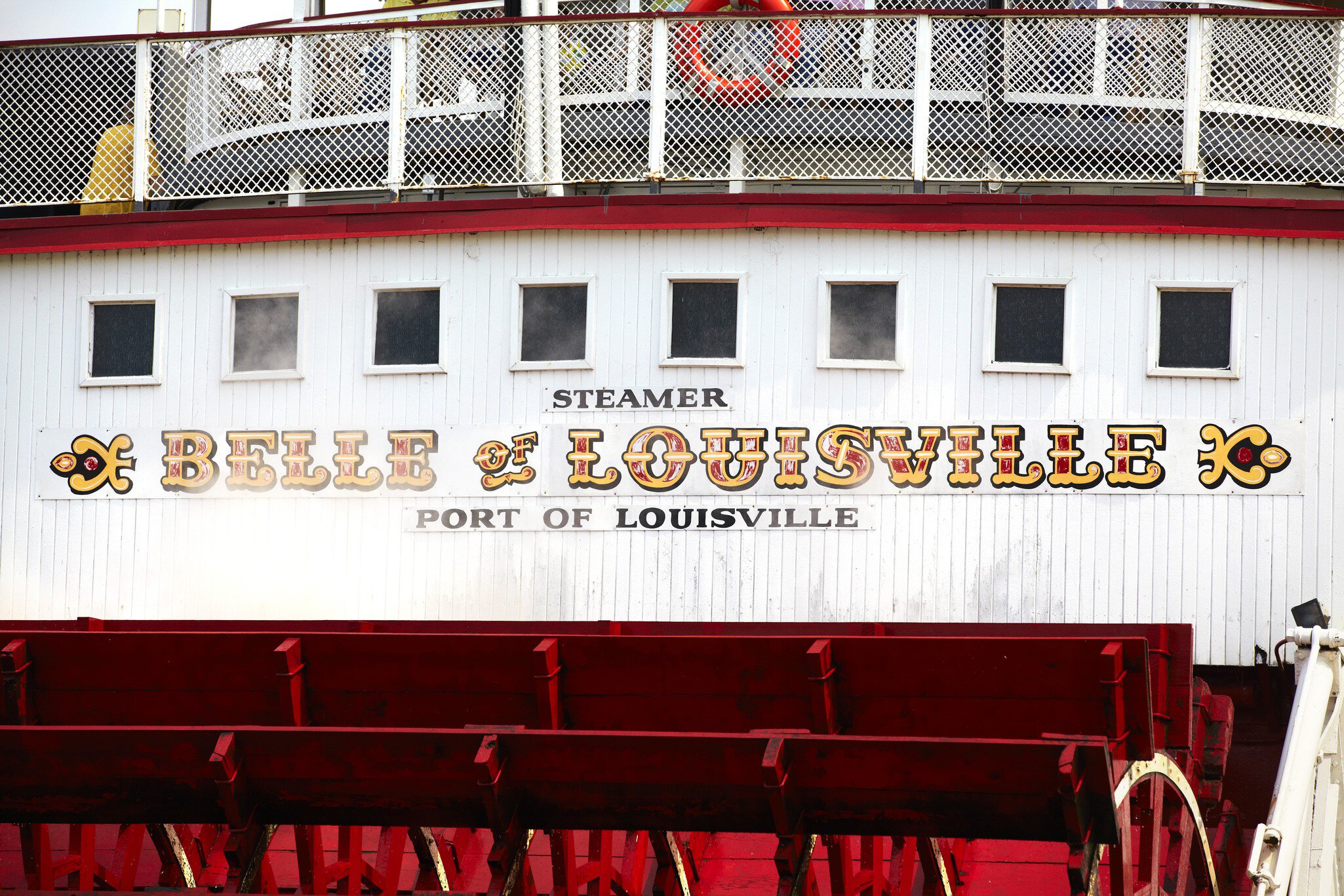 Painted sign above the paddles of the 'Belle of Louisville' on Ohio River.