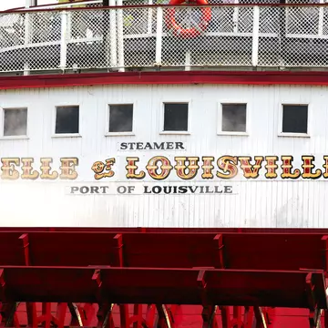 Painted sign above the paddles of the 'Belle of Louisville' on Ohio River.