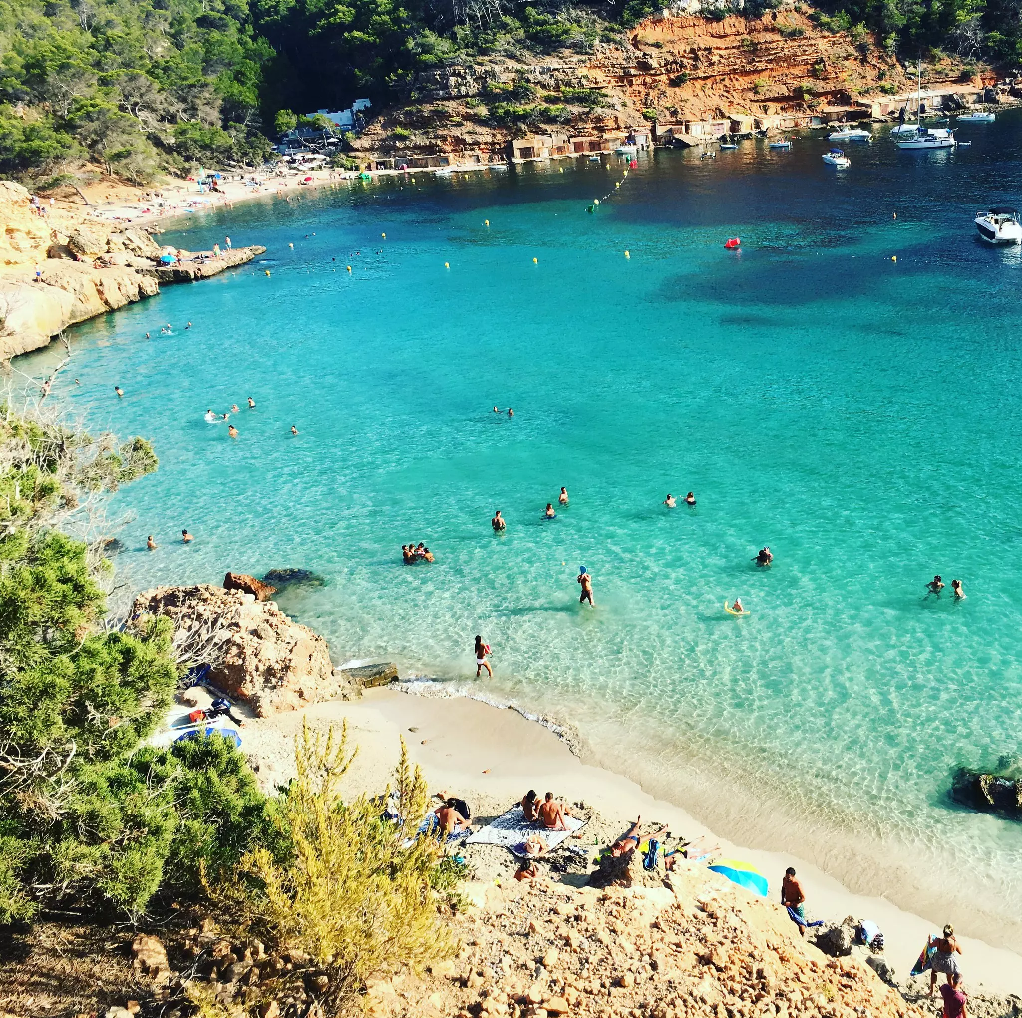 People swimming in the turquoise waters of Cala Salada
