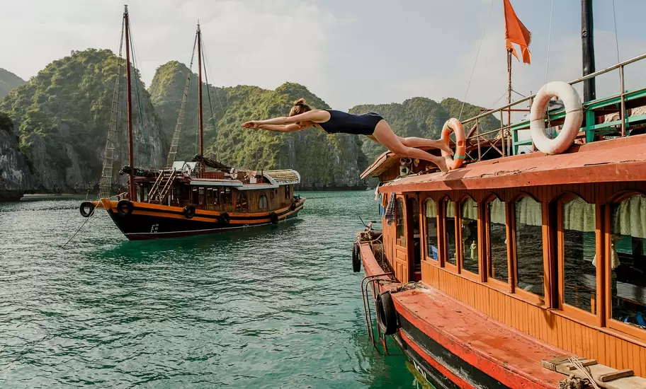 Woman diving off of a boat in Halong Bay Vietnam