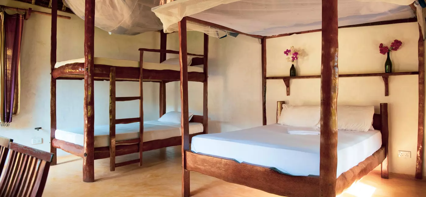 Bunk beds and a double bed with mosquito nets in a spacious dorm room