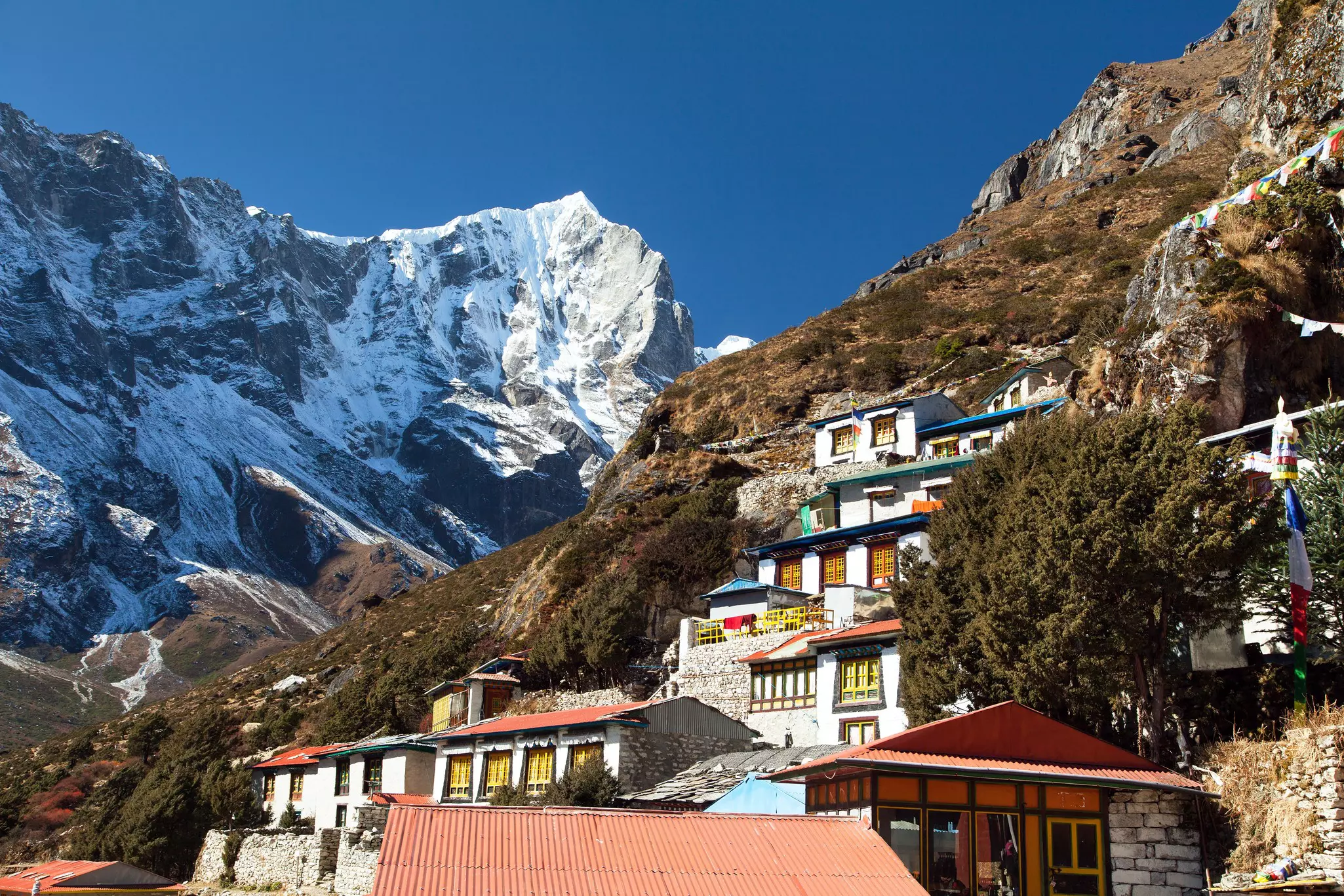 Thame gompa with prayer flags and buddhist symbols - monastery in Khumbu valley on three passes trek, Mount Everest area, Sagarmatha national park, Nepal  
