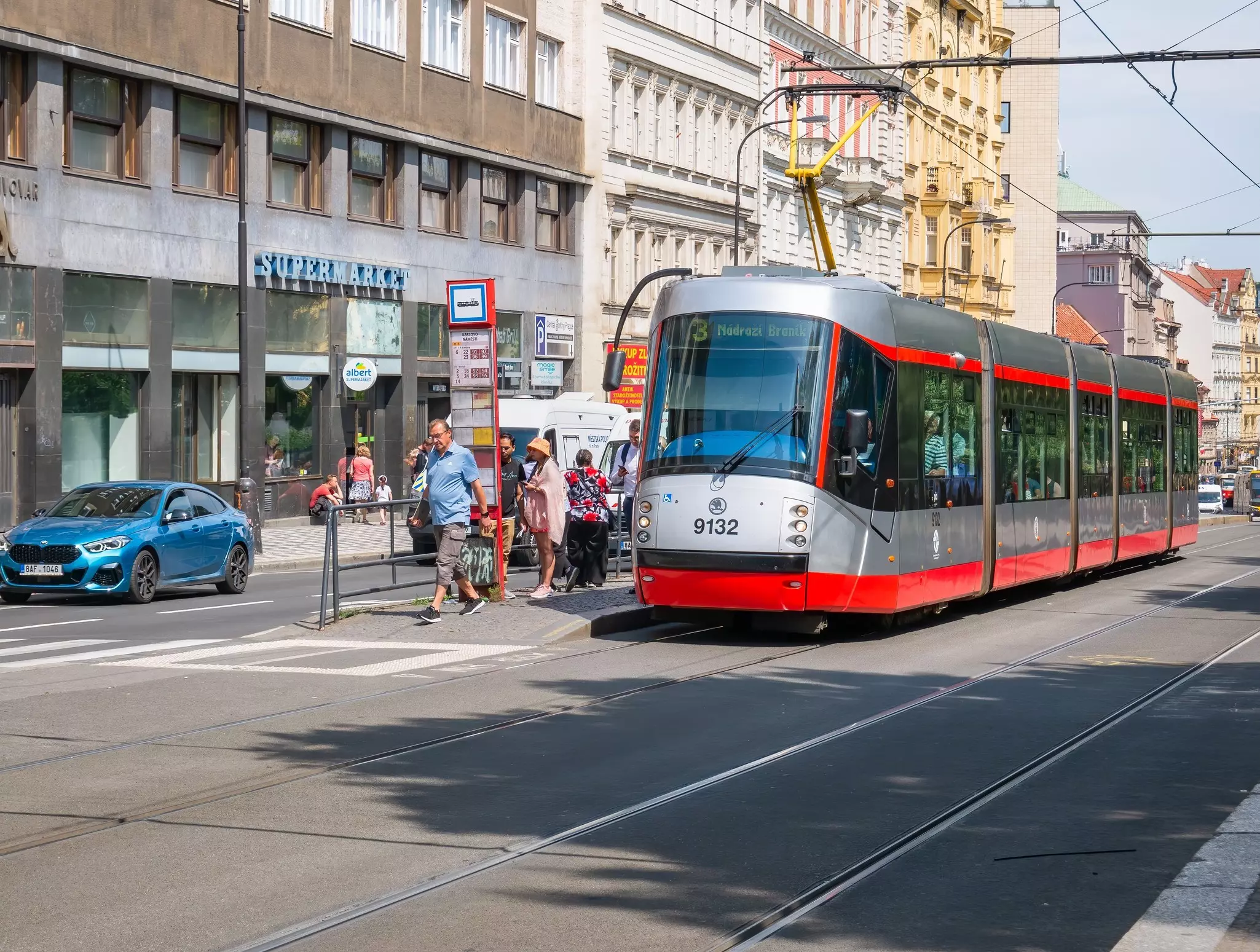 A silver tram with red trim on a city street