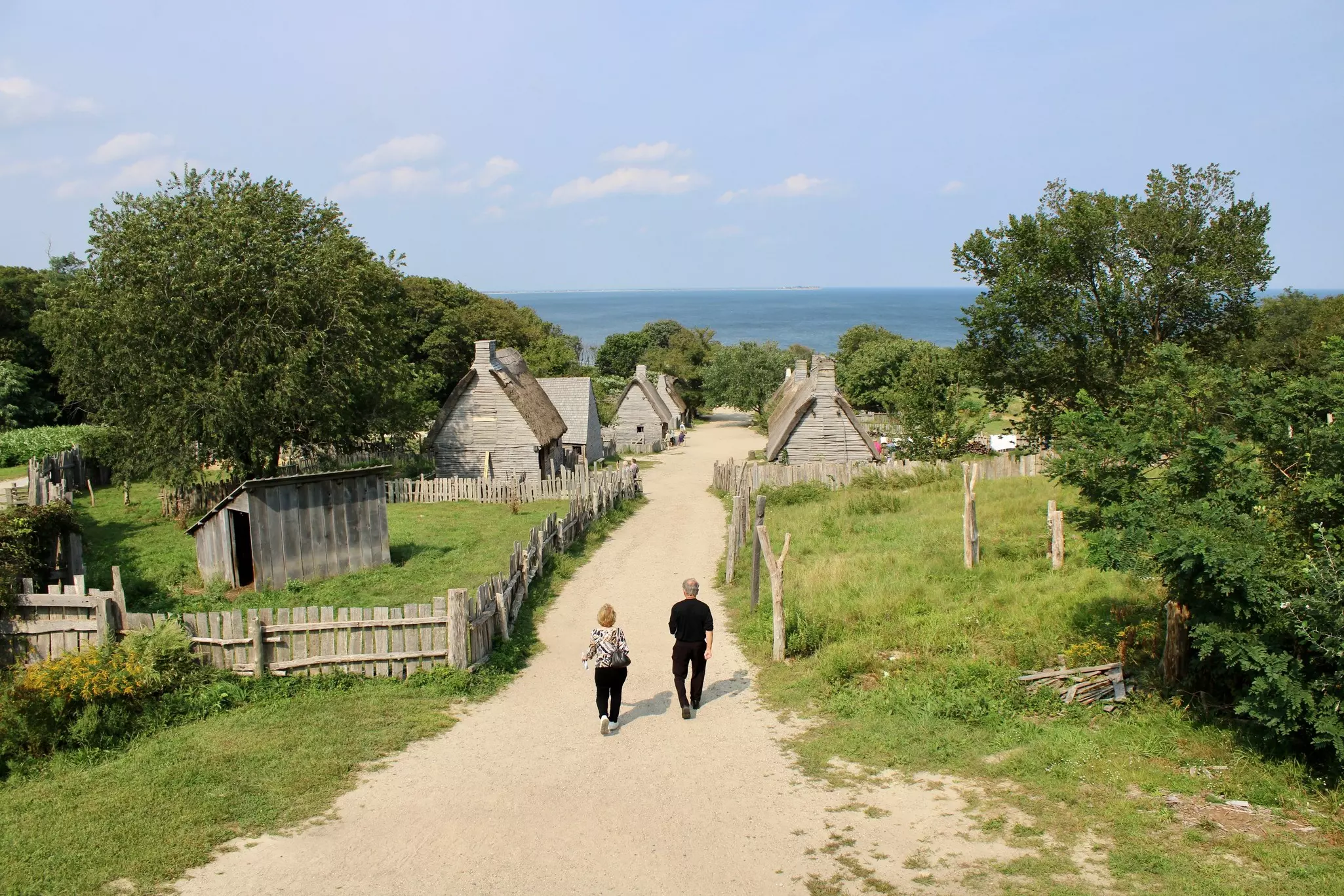 People walking along the dirt road from a bird's eye view of Plimoth Patuxet.