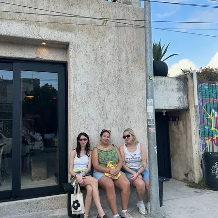 Three friends sat outside a hotel