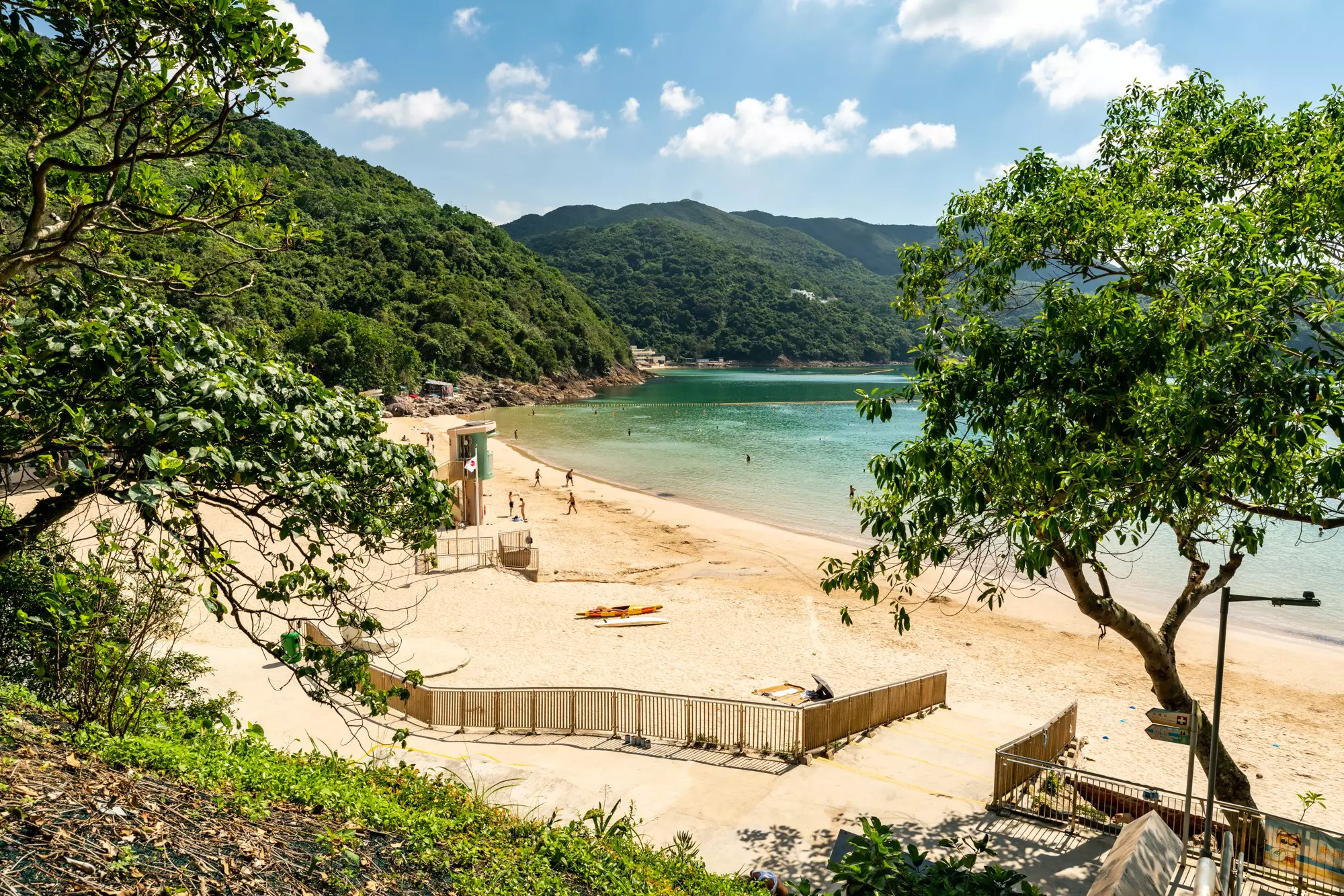 A sandy beach backed by dense jungle. 