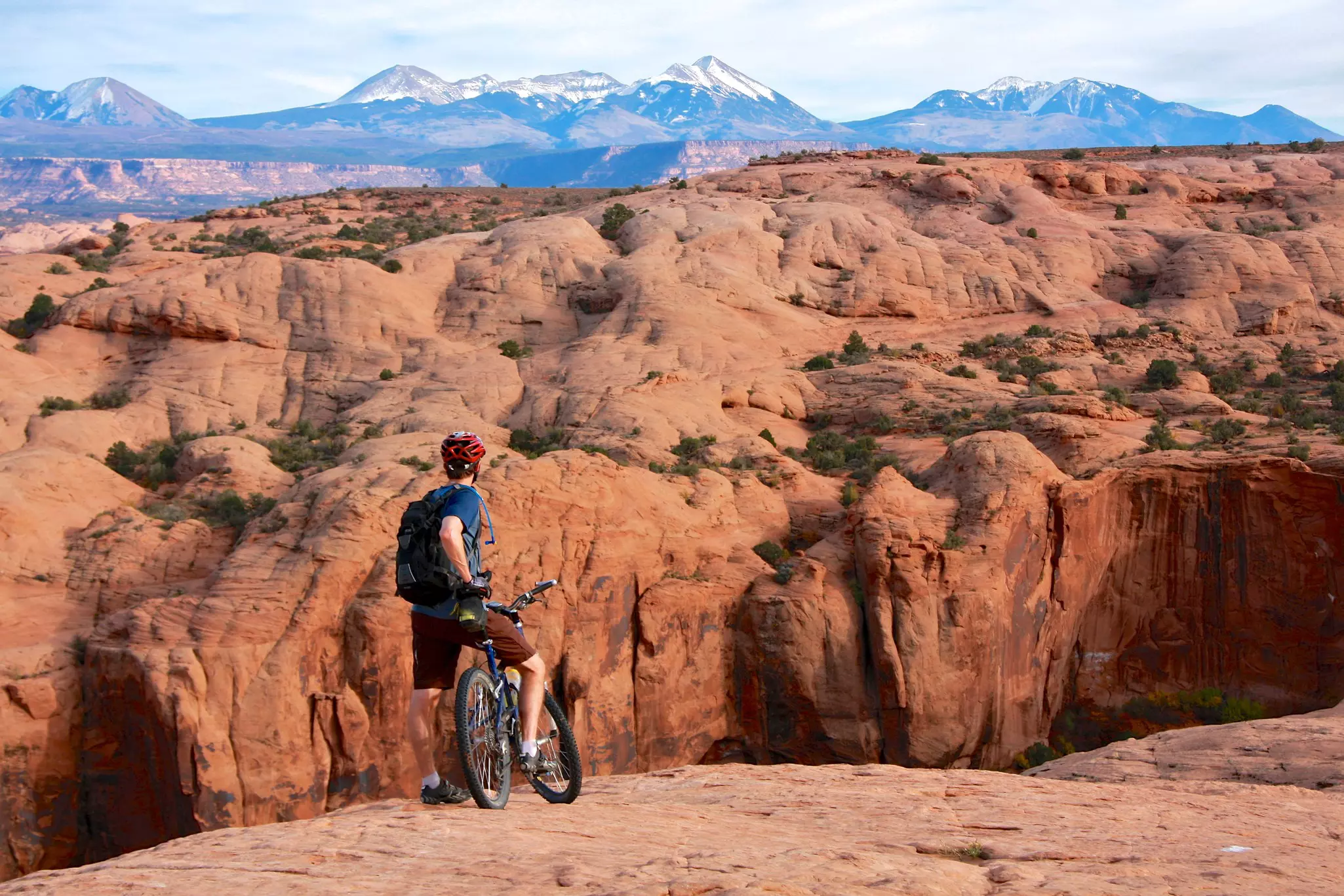 A mountain biker looks over rocky scenery in Moab, Utah, USA.