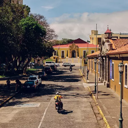A person on a motor bike rides through the street in San Jose, Costa Rica. 