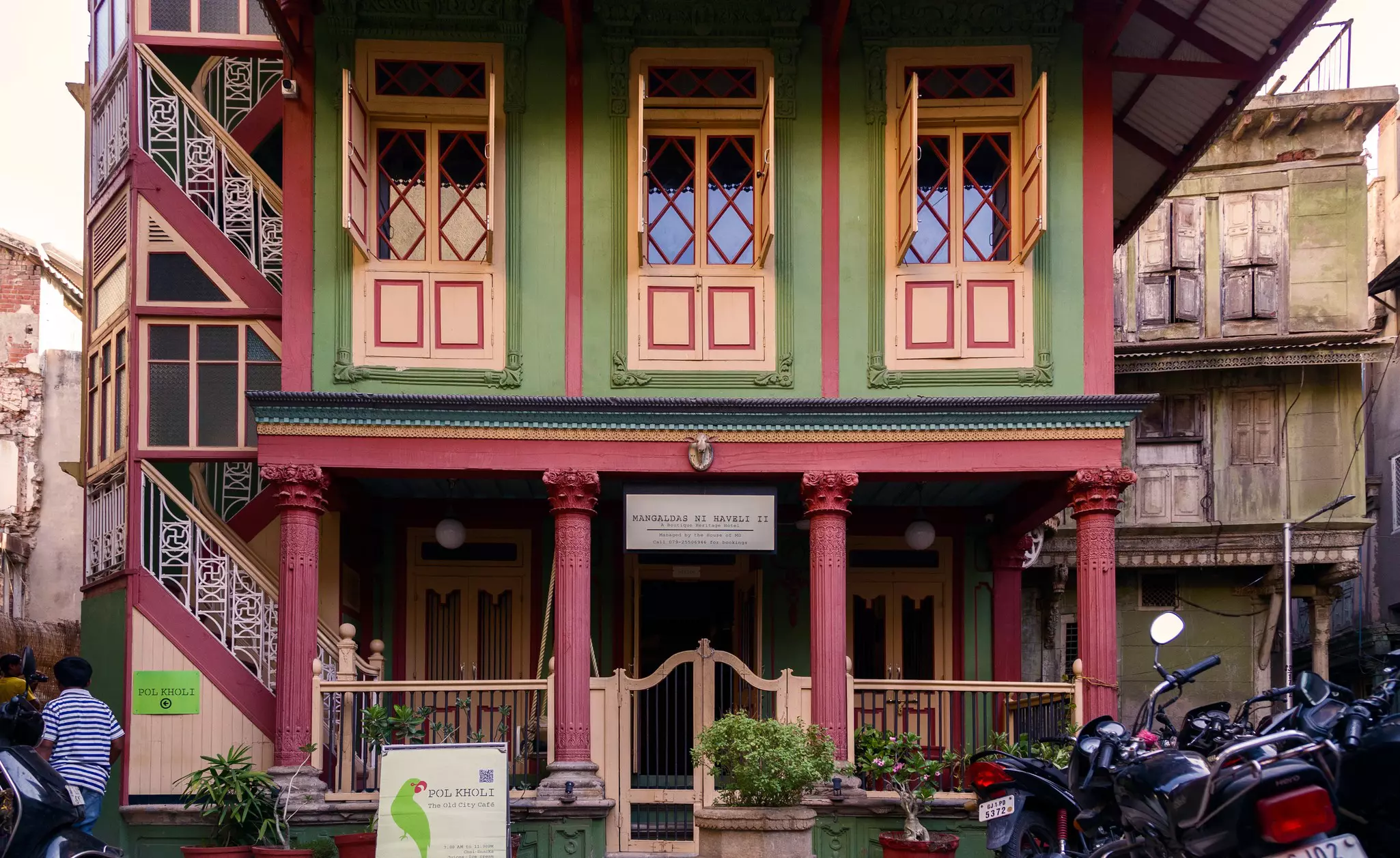 A colorfully painted facade of a historic home in a city. It has been converted into an inn for visitors.