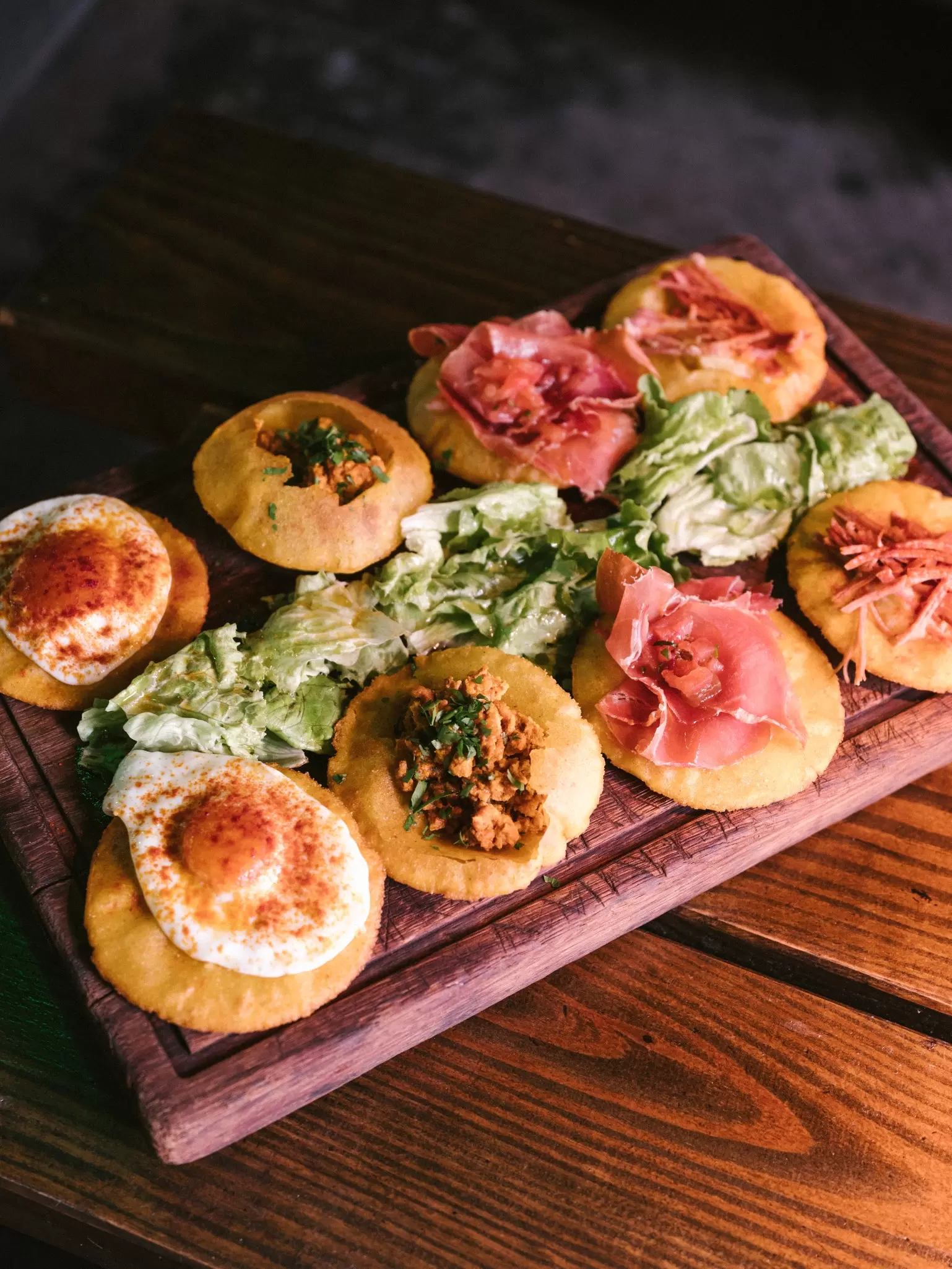 A wooden board of tortos (corn fritters), a popular tapas dish in Asturias, Spain. 