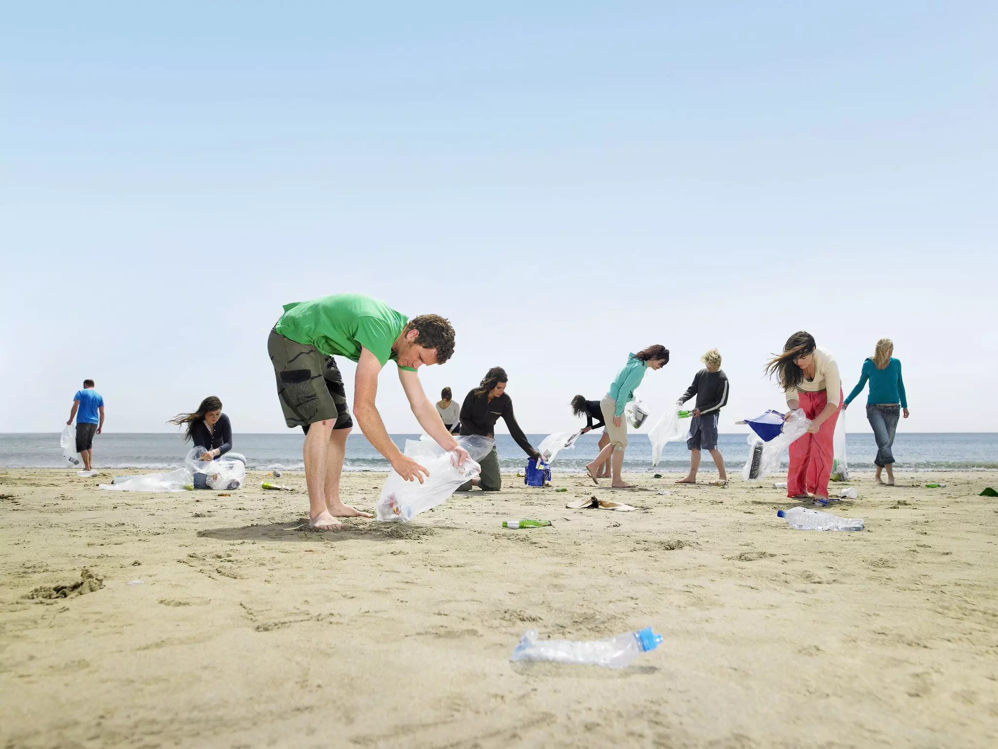 Young people collecting garbage on beach