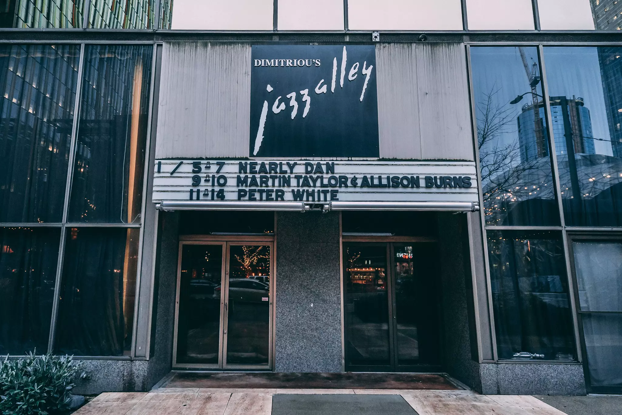 The exterior of a live music venue with a sign listing out three of the upcoming jazz performers.