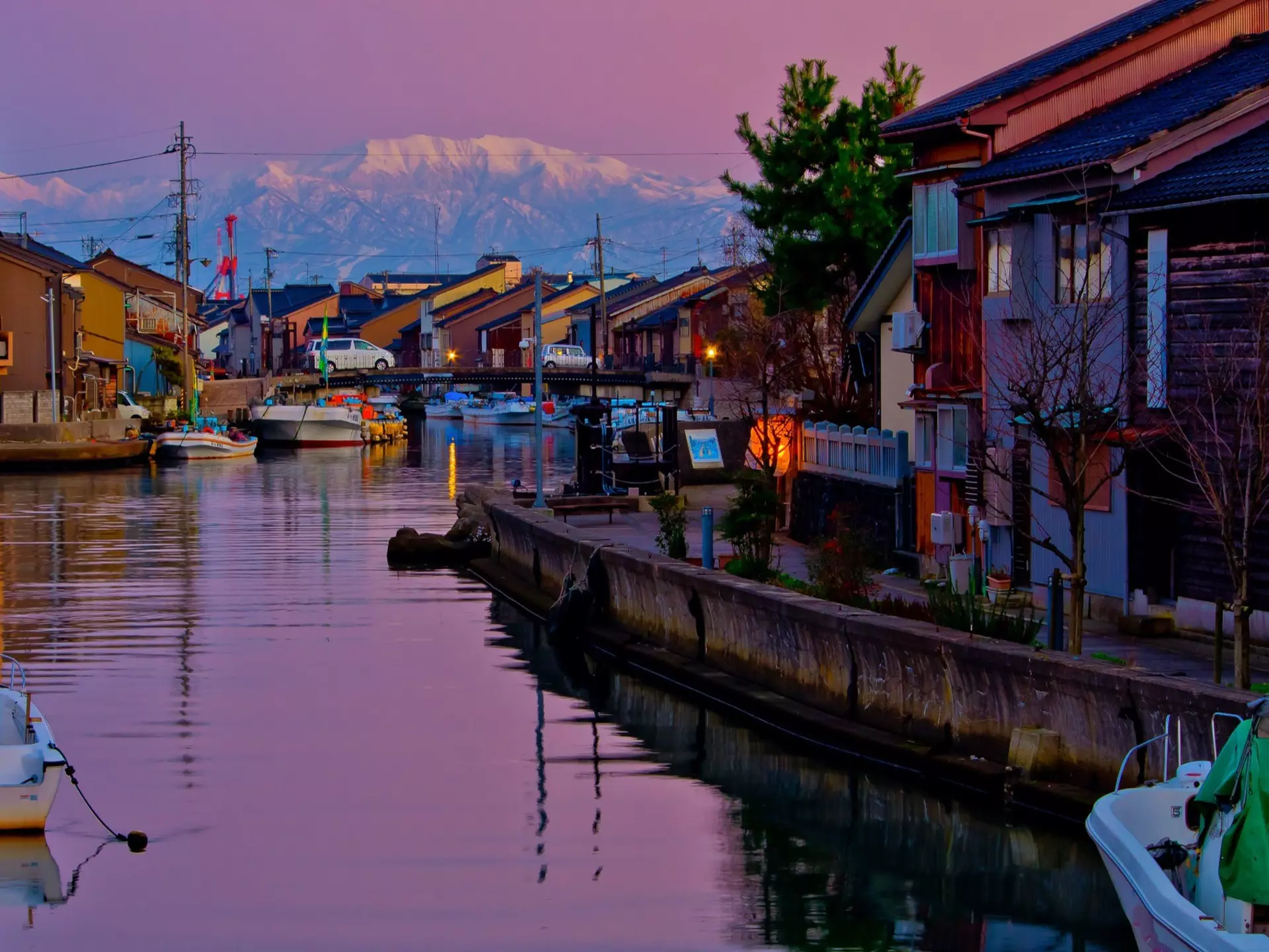 Sailboats Moored On Lake By Buildings In City Against Sky