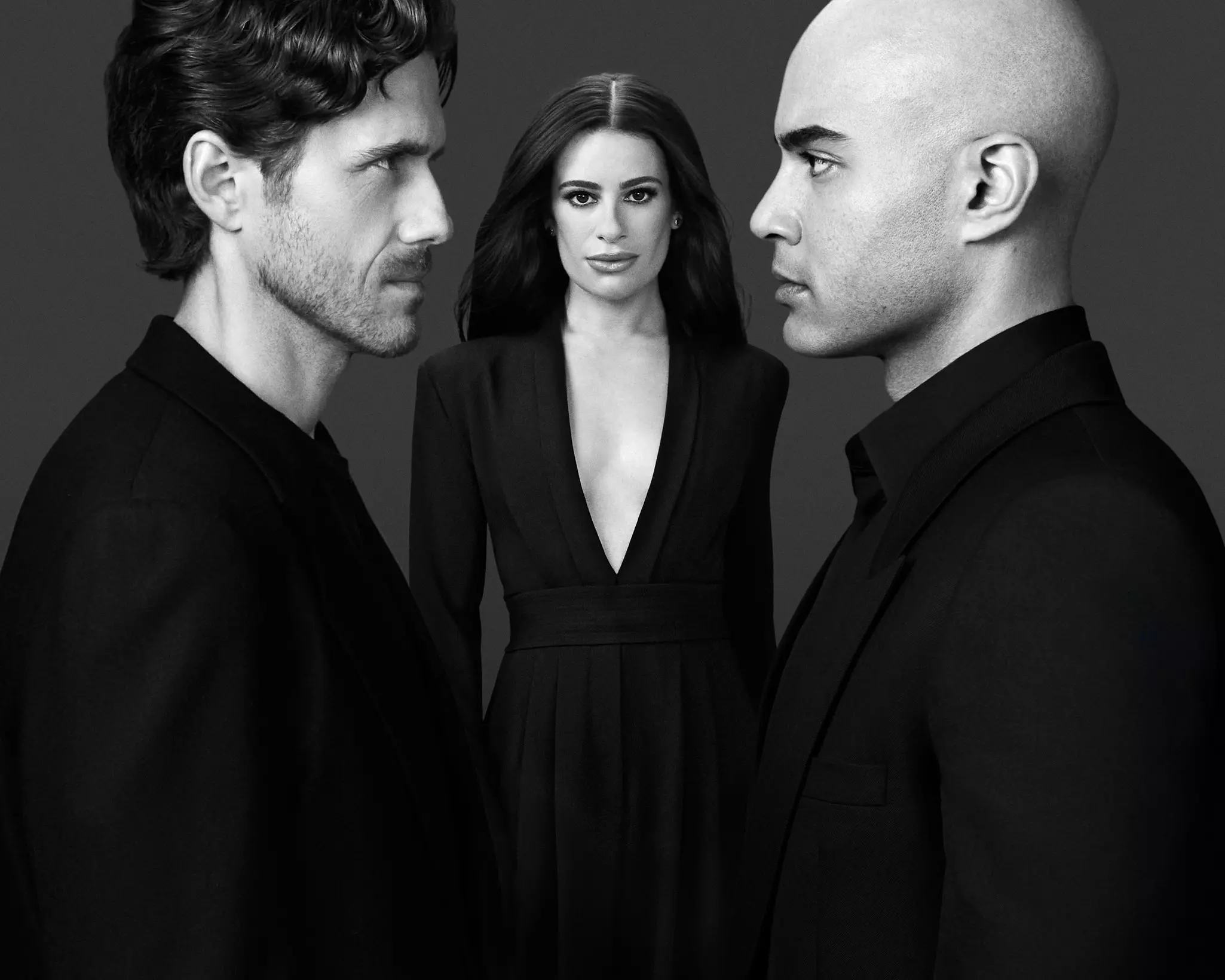 Lea Michele stands between Aaron Tveit and Nicholas Christopher, who face each other, staring