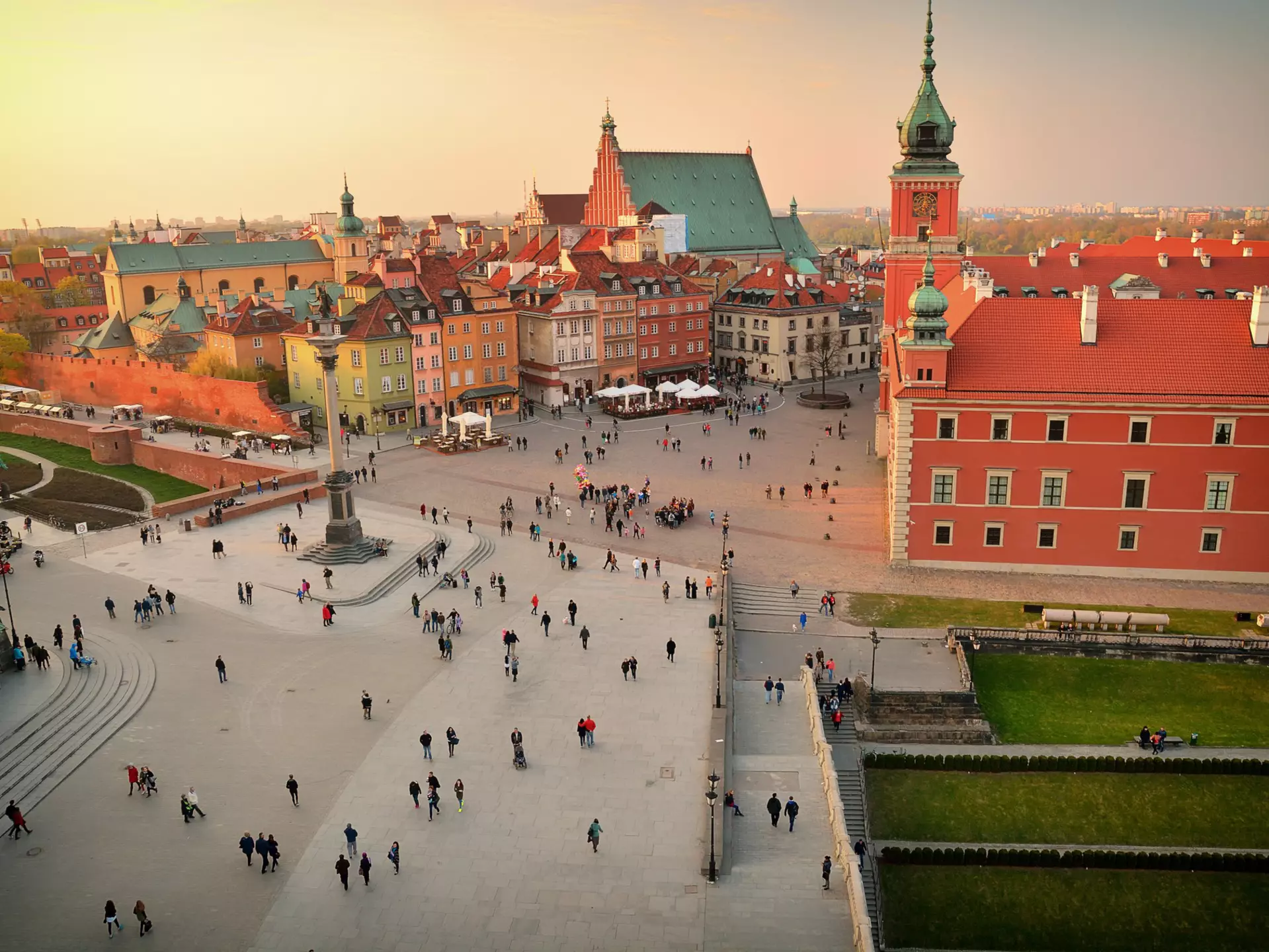 Elevated view of town square, Warsaw. Many people walking through a courtyard during the late afternoon.