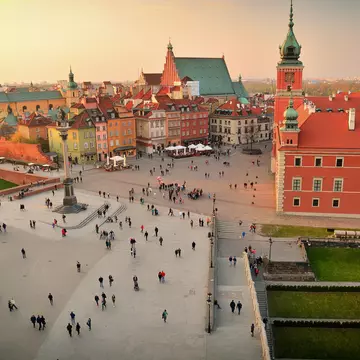 Elevated view of town square, Warsaw. Many people walking through a courtyard during the late afternoon.