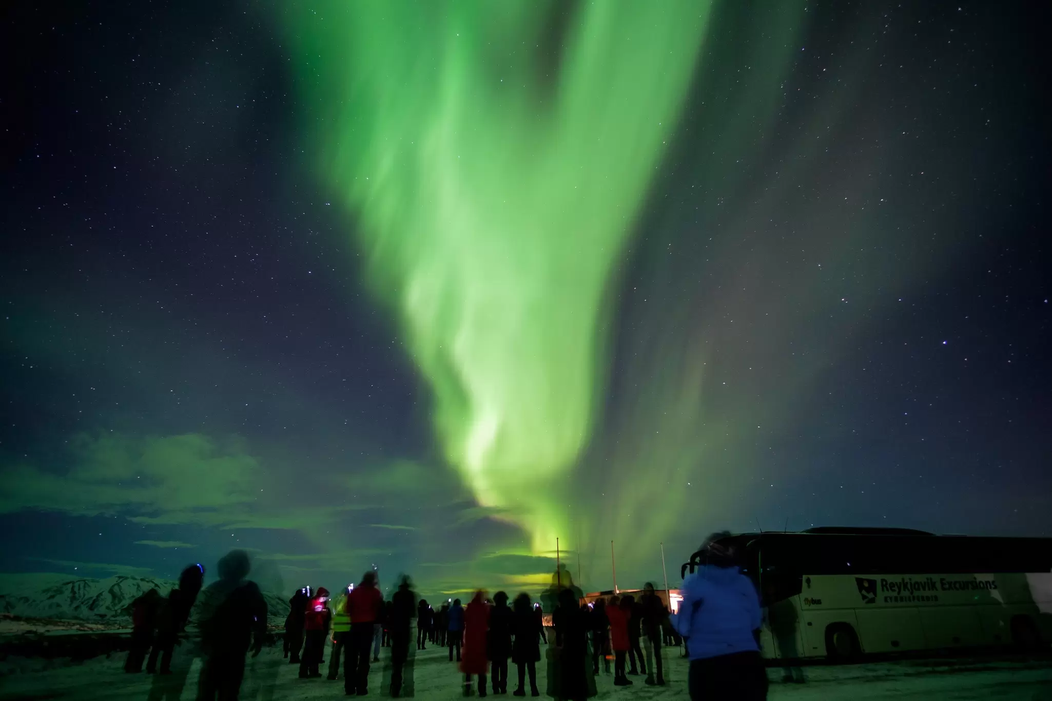 View of Aurora borealis lighting up the night sky over Þingvellir National Park in Iceland.
