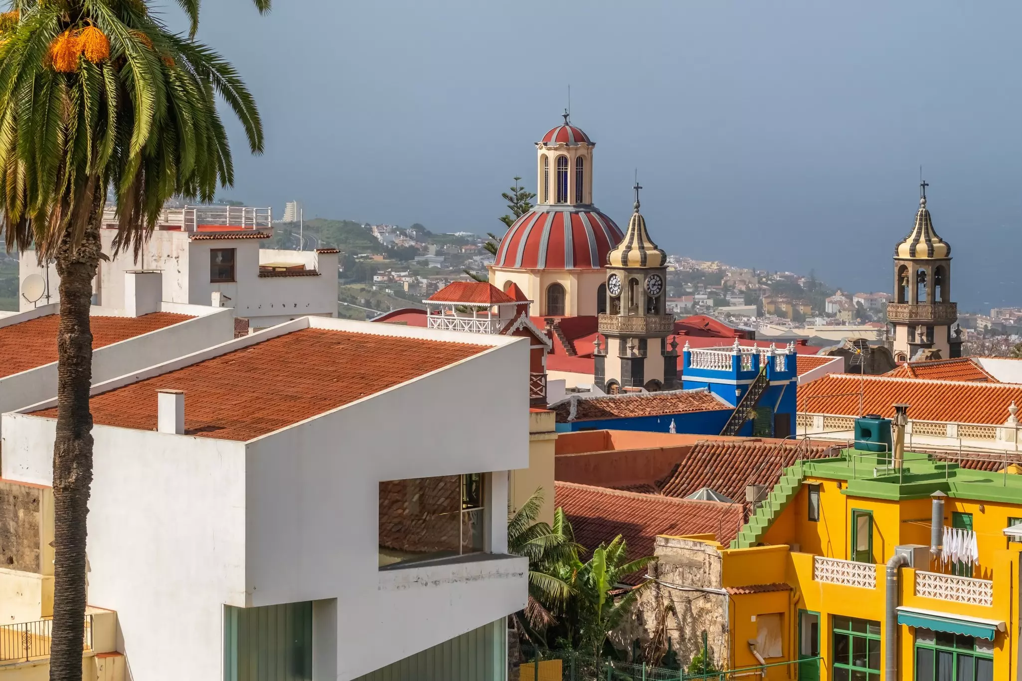 A town with colorful buildings surrounding a terracotta-domed church.