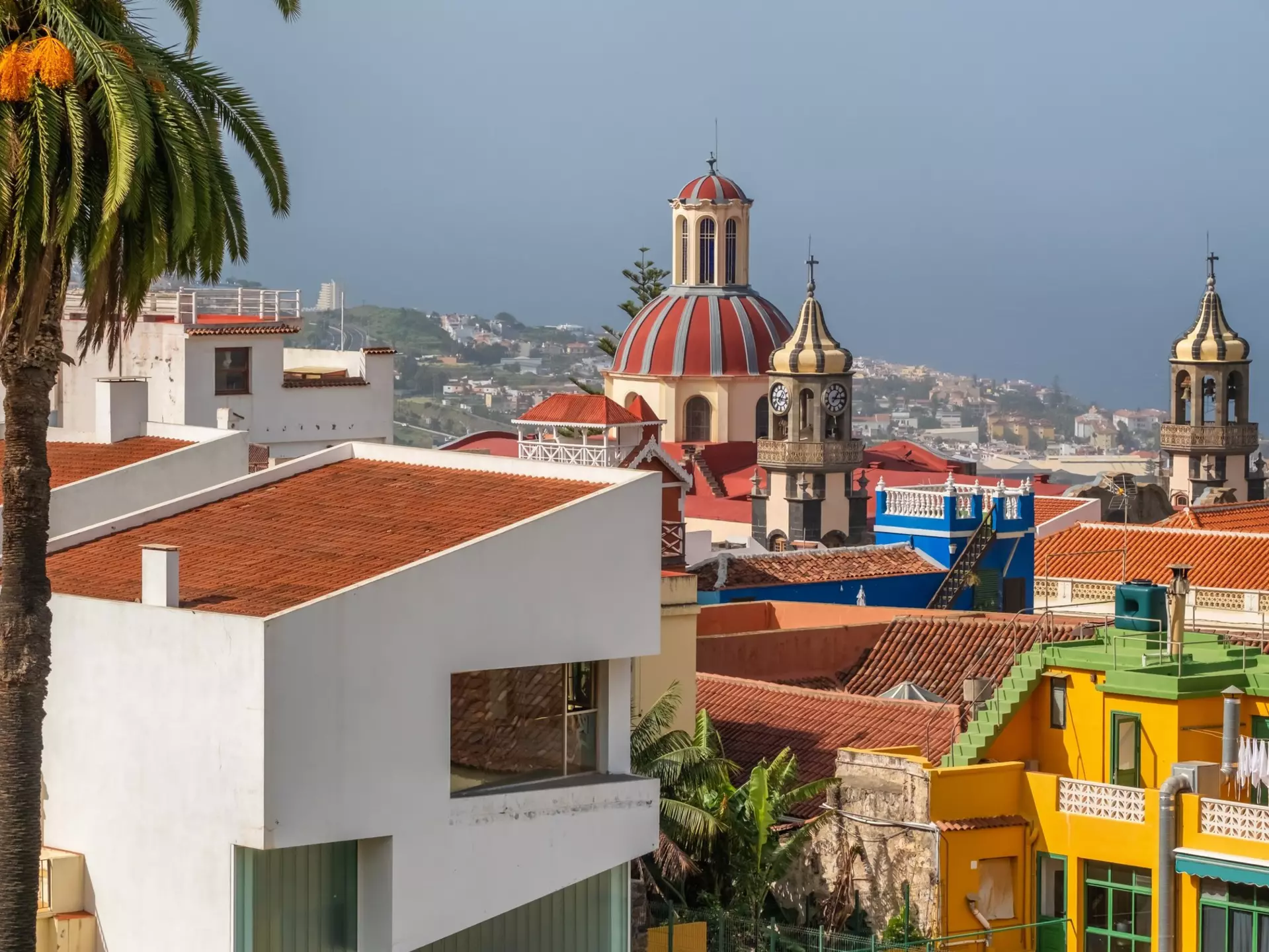 A town with colorful buildings surrounding a terracotta-domed church.