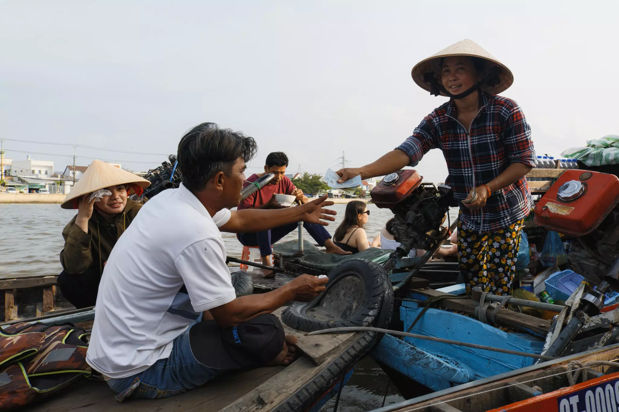 Two people exchange money on boats in the river.