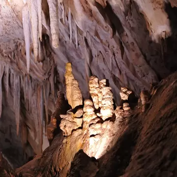 View of illuminated rock formations in the Cueva de los Murcielagos in Zuheros, Spain.