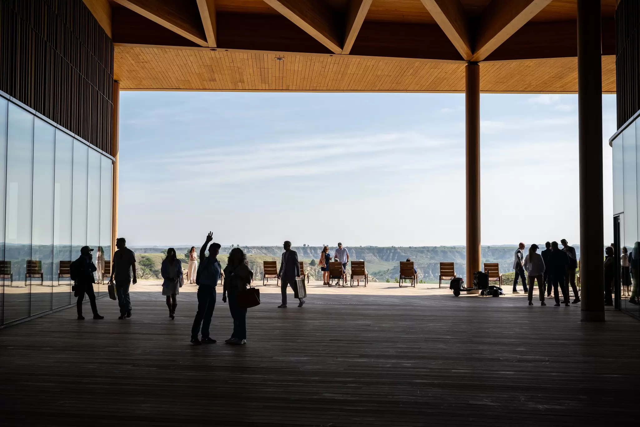 People stand in a covered breezeway between two structures; there is an open view to one side.