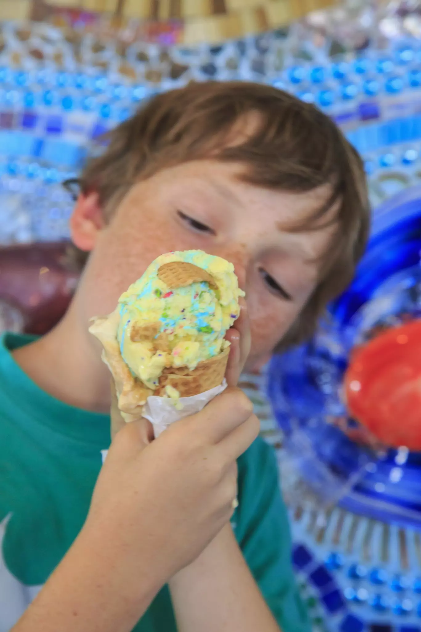 A freckled boy eats an ice cream cone at Pacific Beach in San Diego