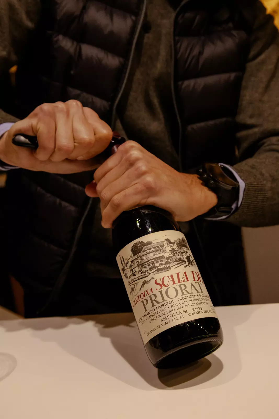A person opening a wine bottle.