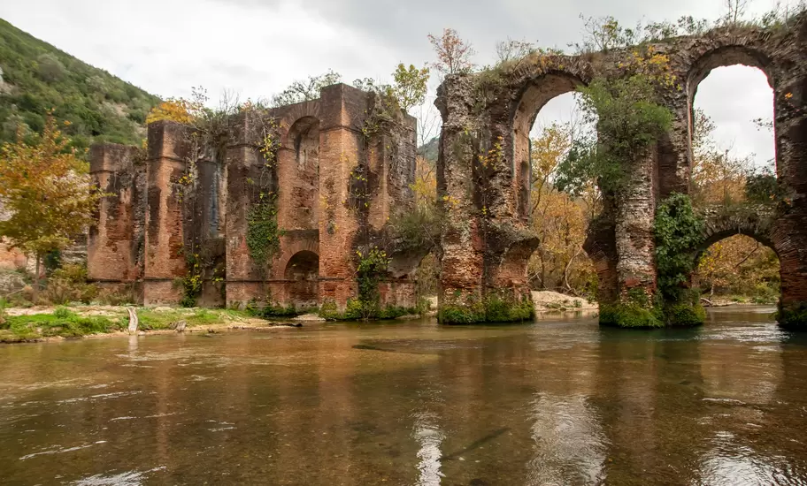 Brick arches of the ruined Roman aqueduct of Nikopolis crossing the Louros River in Preveza region, Greece