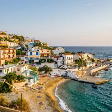 The late afternoon sun shines on the coastal village of Armenistis on the island of Ikaria in Greece.