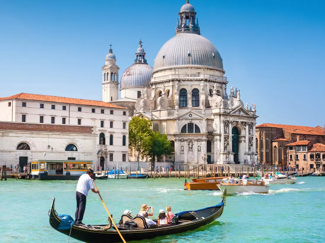 Traditional Gondola on the Canal Grande with Basilica di Santa Maria della Salute in the background in Venice, Italy
