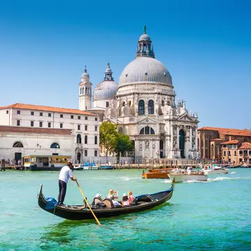 Traditional Gondola on the Canal Grande with Basilica di Santa Maria della Salute in the background in Venice, Italy
