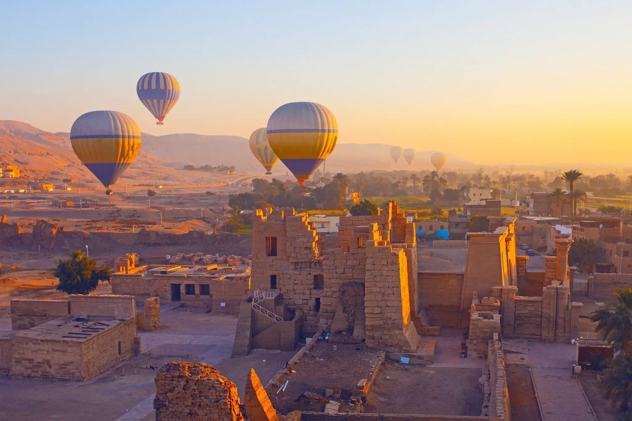 Hot air balloon flying above The Mortuary Temple of Ramesses III at Medinet Habu in Theban Necropolis at Valley of the Kings, Luxor, Egypt