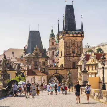 People crossing Charles Bridge in Prague, Czechia