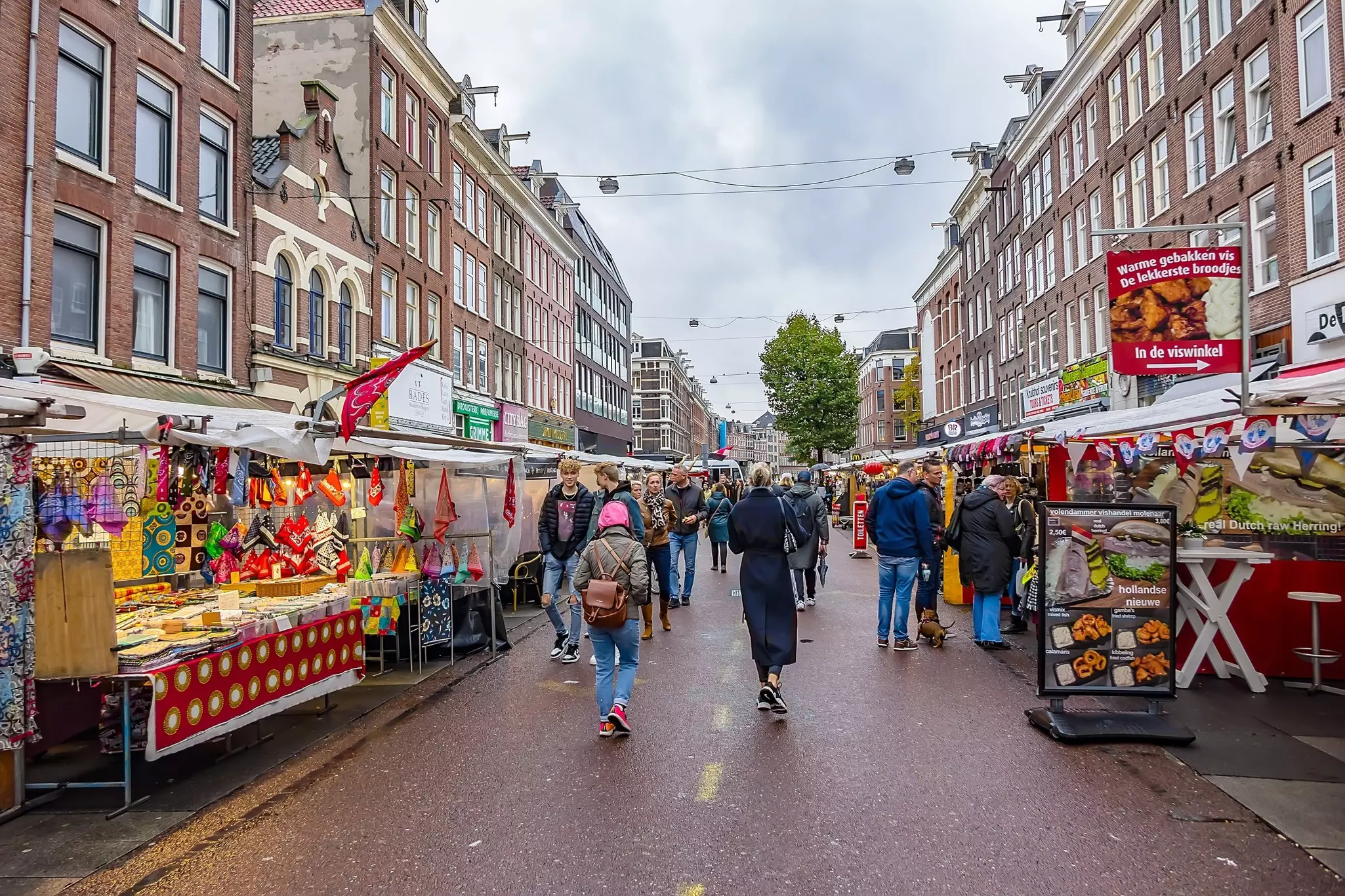 People visiting the Albert Cuyp Market, largest and most popular outdoor market in the Netherlands, a tourist attraction in Amsterdam De Pijp area.
