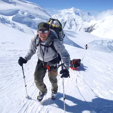 Mountain ranger Brian Scheele on this way to Windy Corner on Mount McKinley, also know as Denali, in Alaska. He is pulling a sled, that together with his heavy backpack is containing all the gear like tents, clothing and food. Every climbing season High Mountain Rangers of the Denali National Park Service are called to help climbers in need. If possible the patient is brought down to Basecamp on foot, only in life threatening conditions a helicopter is called to evacuate the patient to a hospital in Anchorage. Mount McKinley, native name Denali, is the highest mountain peak in North America, with a summit elevation of 20,321 feet (6,194 m) above sea level. At some 18,000 feet (5,500 m), the base-to-peak rise is considered the largest of any mountain situated entirely above sea level. Measured by topographic prominence, it is the third most prominent peak after Mount Everest and Aconcagua. Located in the Alaska Range in the interior of the U.S. state of Alaska, McKinley is the centerpiece of Denali National Park and Preserve.
30-34 Years; Adult; Adults Only; Adventure; Alaska; Alaska - US State; Backpack; Camp; Camping; Caucasian Ethnicity; Cheerful; Climbing; Cloud - Sky; cold-temperature; Color Image; Day; Denali; Denali - Mountain; Denali National Park; Exploration; Extreme Sports; Extreme Terrain; Front View; Full Length; Geology; Happiness; Hiking Pole; Hold; Holding; Horizontal; Men; Mid Adult; Mountain; Mountain Climbing; Nature; Non-Urban Scene; North America; One Man Only; One Mid Adult Man Only; One Person; Only Men; Outdoors; People; Photography; Physical Geography; Scenics; Sky; Sled; Sledge; Smiling; Snow; Snowcapped Mountain; Sunglasses; Sunlight; Tranquil Scene; Tranquility; Travel Destinations; Two People; Warm Clothing; Weather; Winter; Winter Sport;