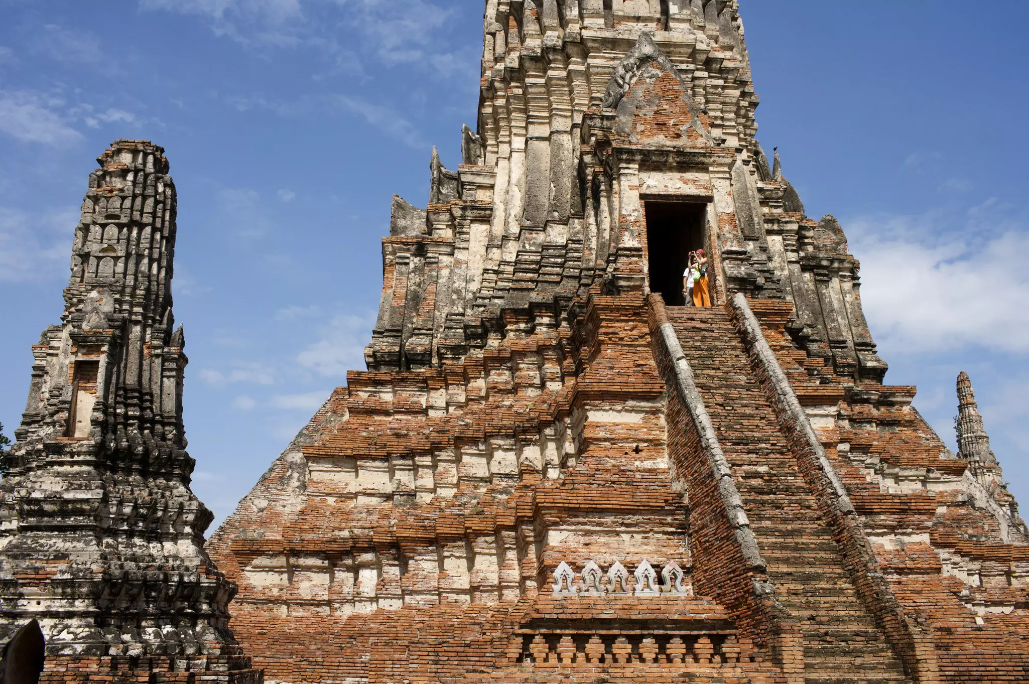 Travelers climb the steps to Wat Chaiwatthanaram