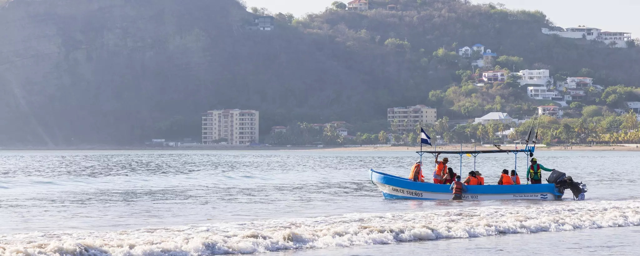 A fishing boat in a bay takes a group of people out on a tour.
