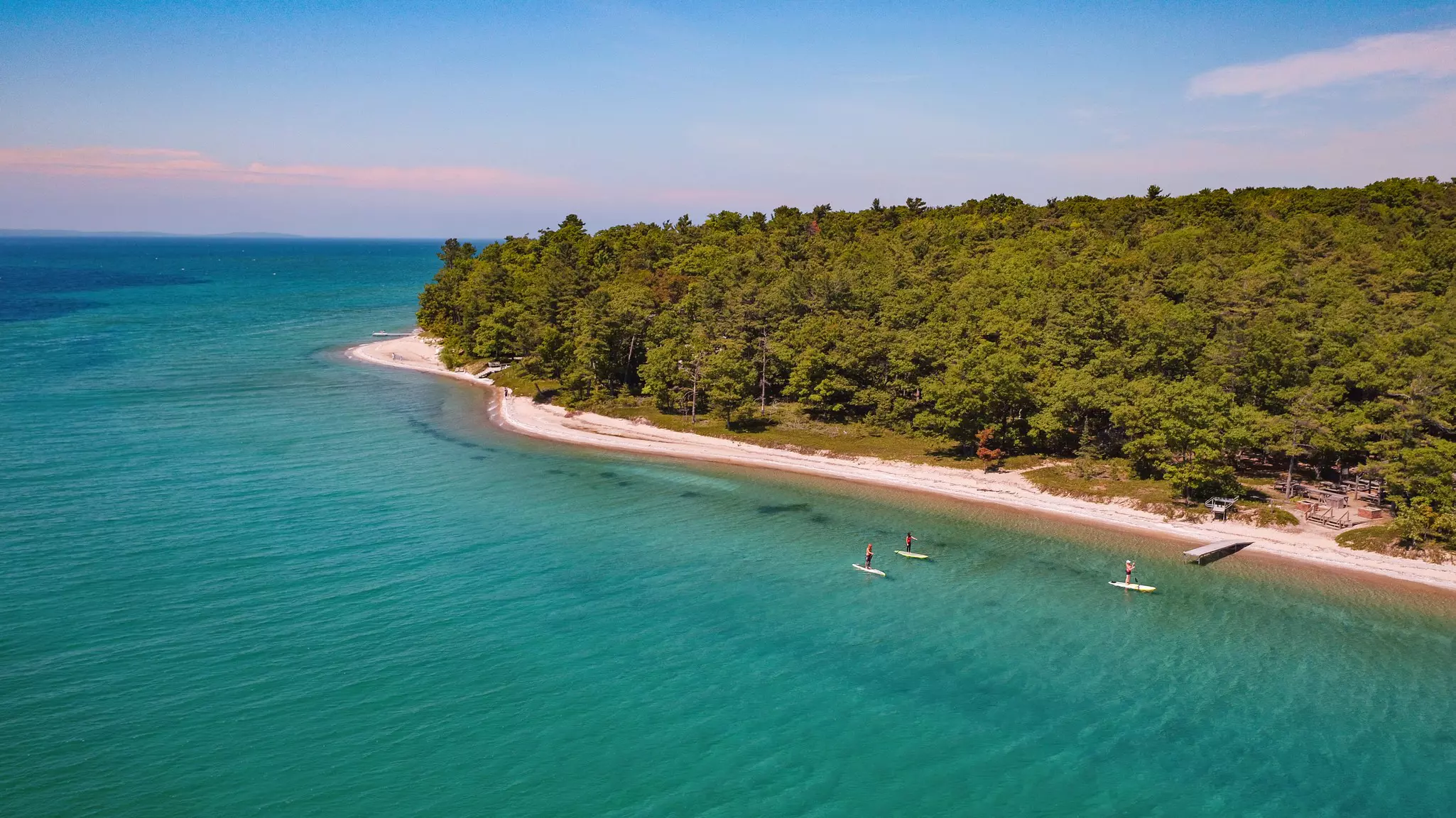 A group of friends explore the west arm of a bay on stand-up paddleboards