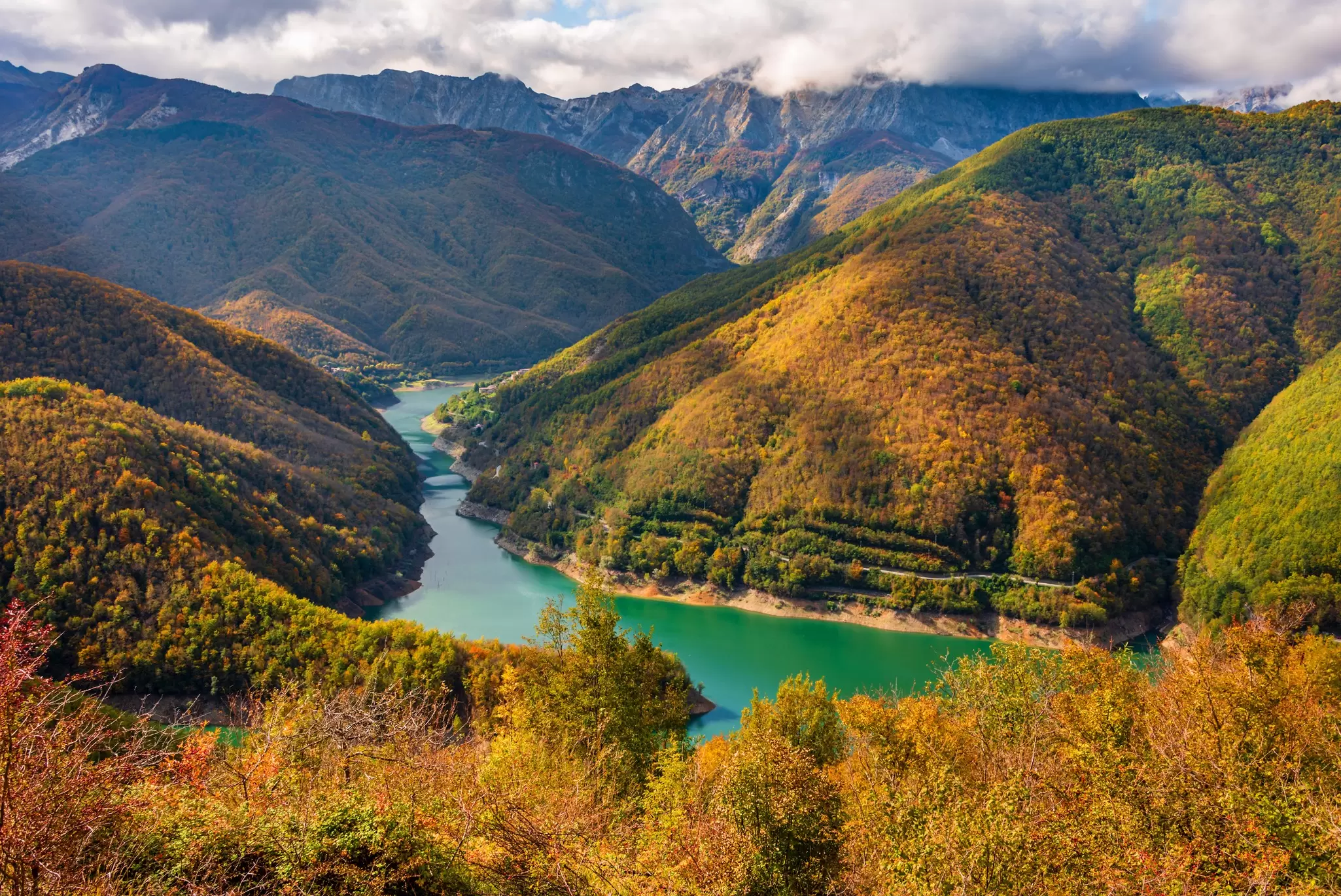 A panoramic view of the lake of Vagli in Garfagnana, seen from the plateau of Careggine, with the Apuan peaks in the background.