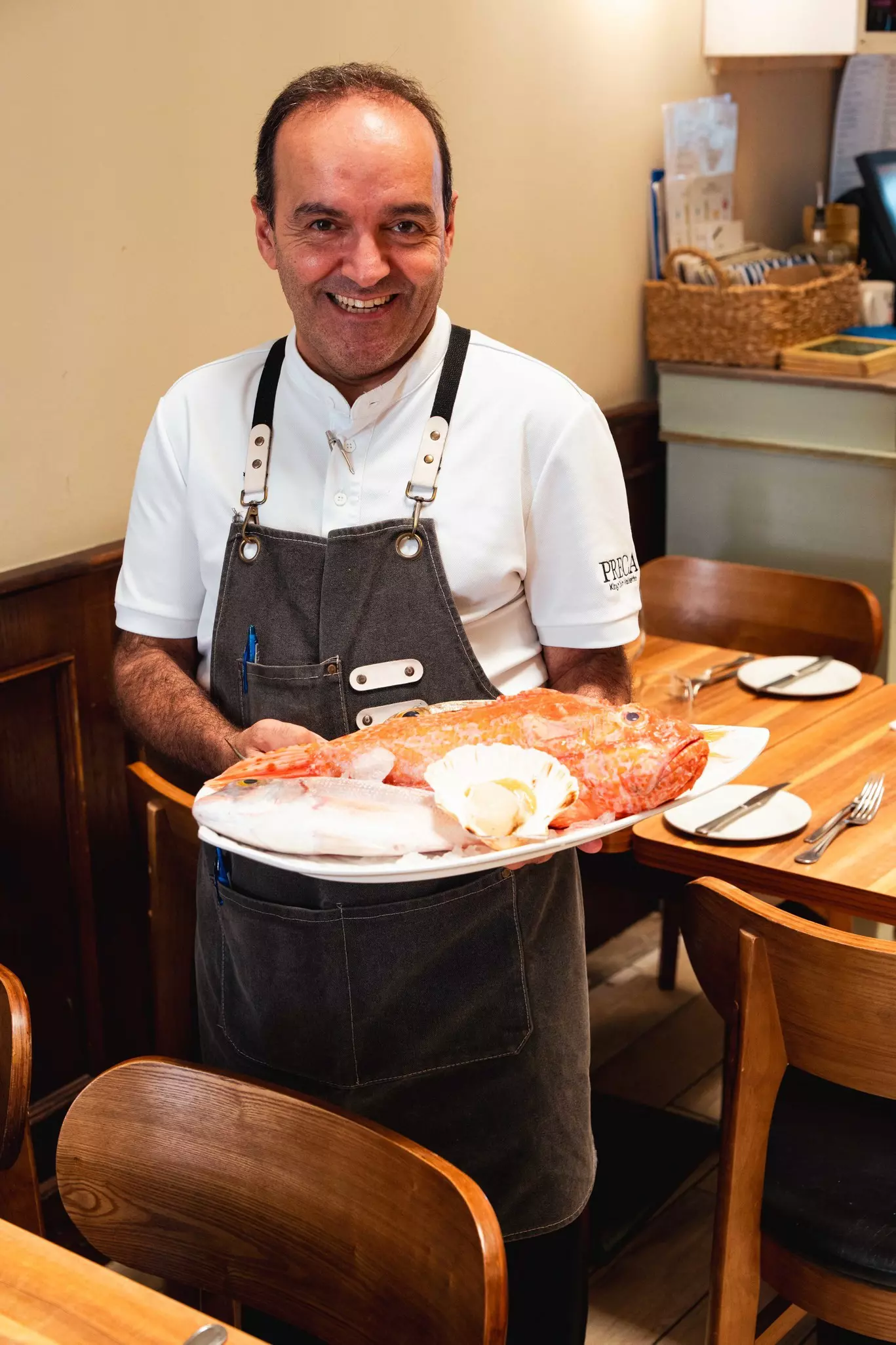 The server at PRECA presents fresh fish for selection