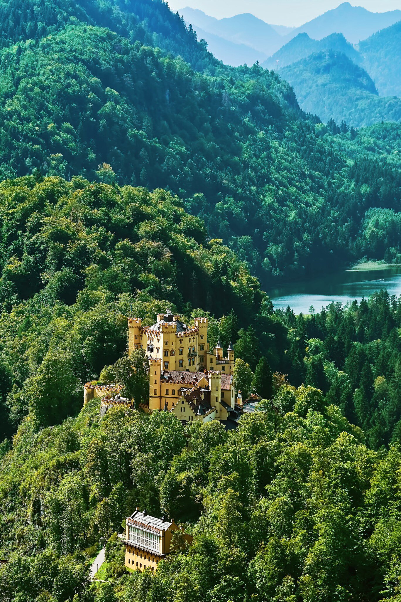 Exterior of Hohenschwangau Castle (Schloss Hohenschwangau or Upper Swan County Palace) set among mountainous forests.