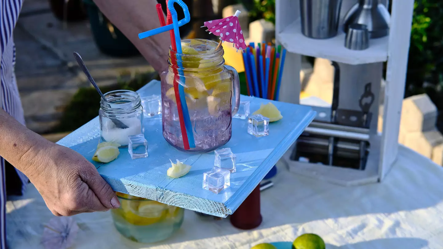 Waitress brings a cocktail on her blue wooden tray